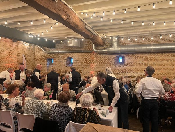 A group of people sitting at tables in a room
AI-generated content may be incorrect.