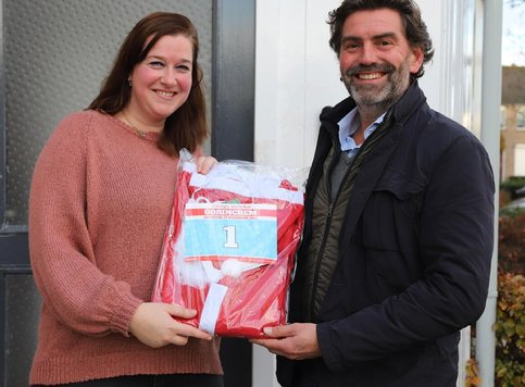 Prijswinnares Priscilla Sleeuwenhoek krijgt haar pak overhandigd van Frank Visch (voorzitter Rotary Santa Run)