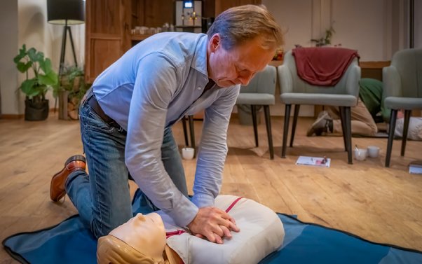 A person practicing cpr on a mannequin

Description automatically generated