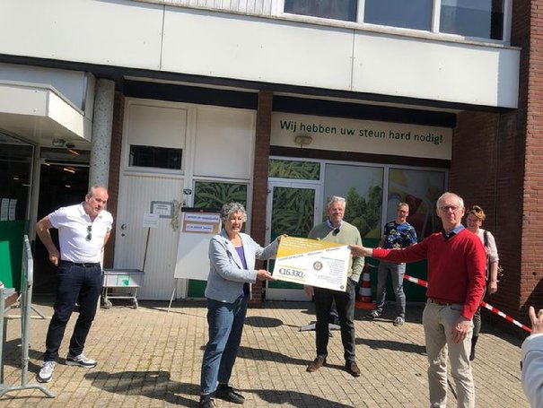 Vera de Hart van de Voedselbank Midden Twente ontvangt de cheque, samen met een college van de Voedselbank Enschede. In het midden voorzitter Henk Bijen van de rotary Hengelo.