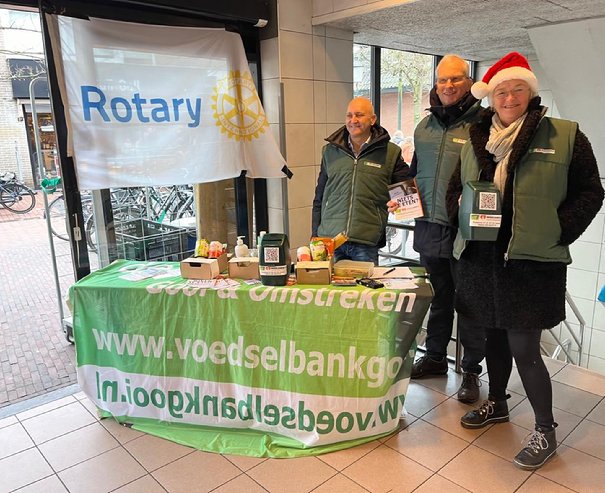 A group of people standing in front of a table

Description automatically generated