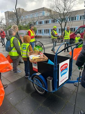 A group of people standing next to a cart

Description automatically generated