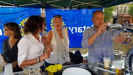 A group of people standing around a table

Description generated with very high confidence