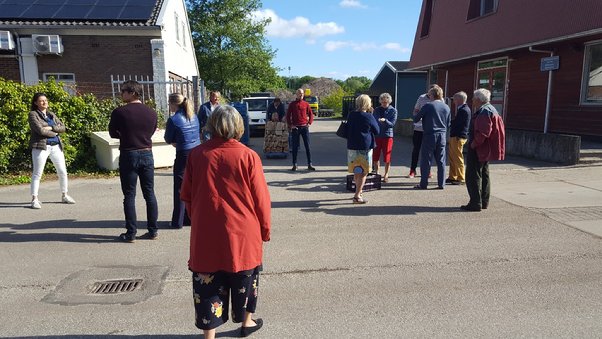 A group of people walking in front of a building

Description automatically generated