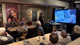 A person standing in front of a group of people sitting at tables

AI-generated content may be incorrect.